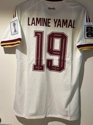 Spanien Vm 2026 Lamine Yamal - En Spanien tröja Vm 2026 med Lamine Yamal i spelar Version storlek XL men har också L 