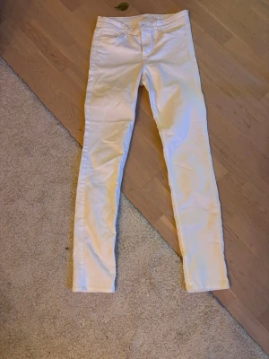 Vita skinny jeans från Bik Bok - Säljer ett par vita skinny jeans från Bik Bok i stretchigt denimtyg. Modellen är tight med låg midja och klassiska fem fickor. Perfekta för dig som gillar en clean och fräsch look till vardags eller när du vill sticka ut lite extra.