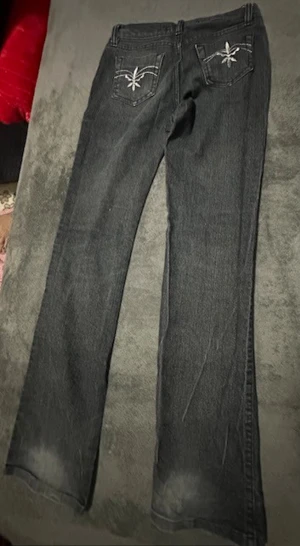 Svarta bootcut jeans - Säljer ett par svarta bootcut jeans med diskret tvättade detaljer. Jeansen har klassisk femficksdesign och raka ben som går ut något nedtill. Perfekta för dig som gillar en avslappnad men ändå stilren look.