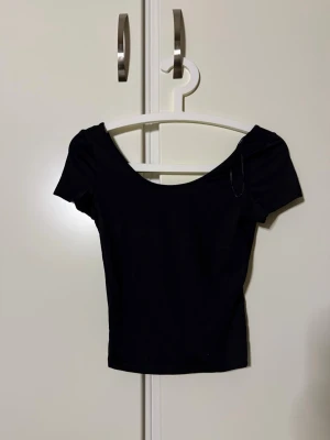 Svart T-shirt från H&M - En stilren svart T-shirt i ”träningsmaterial” och rundad urringning. Perfekt för en trendig look. Tunn och mjuk i materialet, enkel att styla till olika outfits. Endast använd vid ett tillfälle så iprincip nyskick💗