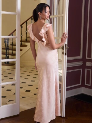 Ljusrosa långklänning med volang - Elegant ljusrosa långklänning i glansigt material med v-ringning, volangdetaljer vid axlarna och öppen rygg. Klänningen har en smickrande passform och tunna axelband. Perfekt för speciella tillfällen. Själjer pågrund av att den inte passar helt ny med prislapp 