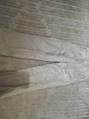 Beiga raka linnebyxor - Snygga beiga linnebyxor med rak passform och resår i midjan. Perfekta för en avslappnad och trendig look. Tillverkade i ett lätt och luftigt linnematerial som känns skönt mot huden.