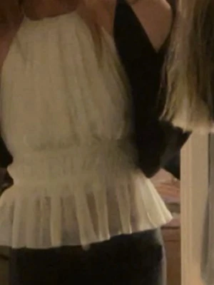 Öppen rygg halterneck topp - Supersöt volang topp med halterneck och öppen rygg Toppen är ärmlös och har en luftig, flowy passform som ger en romantisk vibe. Perfekt att styla med jeans eller kjol för en trendig look.