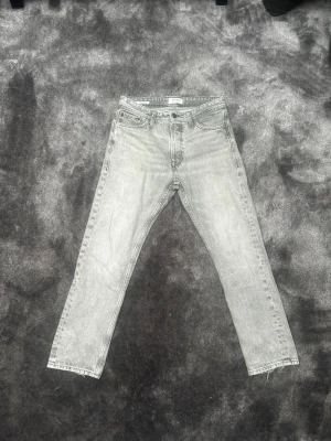 Gråa raka jeans från Jack and Jones - Säljer ett par gråa jeans från Jack and Jones med rak passform och klassisk femficksdesign. Jeansen är i modellen Loose Chris och storlek W28 L30. Priset kan diskuteras.