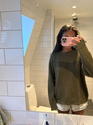 Olivgrön oversized stickad tröja - Mysig olivgrön stickad tröja med avslappnad, oversized passform och rund halsringning. Långa ärmar och mjukt material ger en chill vibe. Storlek XL men passar mig som har xs/s i storlek i vanliga fall!