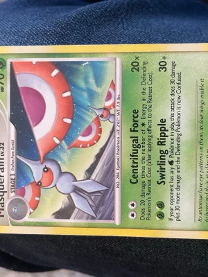 Pokémonkort Masquerain lv.32 - Säljer ett samlarkort från Pokémon med Masquerain lv.32. Kortet har en färgglad illustration med gröna, röda och vita toner och detaljerad design. Perfekt för dig som gillar att samla eller spela Pokémonkort.