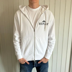 Replay Hoodie - Riktigt schysst vit zip hoodie från märket Replay. Storlek S men kan även passa M. Skick 9,5/10 endast en liten svart fläck som kan ses om man kollar riktigt noga på sista bilden, lägs inte märke till annars. Modellen är 183 och väger ca 70 kg, hör gärna av er vid funderingar!🤗