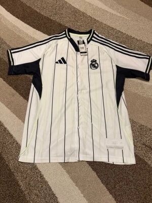 Real Madrid - Special Edition  - Säljs av ICEKIT  Storlek: XL Namn + nummer: Inget Badge: Ingen  Här kan du se tröjor i ICEKIT Outlet. Alla tröjor är helt nya och utan några problem. Du kan välja att köpa dem här eller direkt via vår hemsida.  Tröjorna finns tillgängliga hos ICEKIT på: https://www.icekit.se  Länk: https://www.icekit.se/collections/outlet