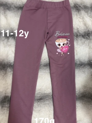 Lila byxor med ballerina cappuccina -tryck - Lila byxor med resår i midjan. På ena benet finns ett tryck av en söt ballerina cappuccina och texten 'Balerina Cappuccino Love' med små hjärtan. Perfekt för dig som gillar dans och gulliga detaljer.🌸 Fick som present när farmor var utomlands men passar inte. Endast testade. Storlek 11-12 år 
