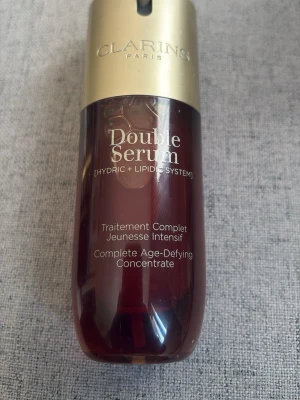 Clarins Double Serum ansiktsserum - Clarins Double Serum är ett anti-age ansiktsserum i en brun och guld plastflaska med pump. Produkten kombinerar hydric och lipid system för intensiv hudvård och lyster. Passar dig som vill boosta huden med fukt och näring.