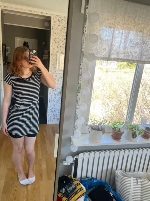 Randigt svartvitt nattlinne - Säljer ett randigt nattlinne i svart och vitt med korta ärmar och rund hals. Modellen är rak och lite längre. Materialet känns mjukt och skönt mot huden.