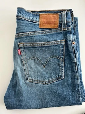 Levi's 501 jeans  - Klassiska blå jeans från Levi's med rak passform och fem fickor. Jeansen har den ikoniska röda Levi's-lappen på bakfickan och är gjorda i slitstarkt denimtyg. Perfekta för en avslappnad och tidlös stil. Storlek w28 l28