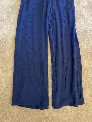 Mörkblå vida linnebyxor - Säljer ett par mörkblå linnebyxor med matchande topp till! St 140 från HM. Har testat dessa engång och sedan har jag växt ur dom! Svala och sköna!❤️