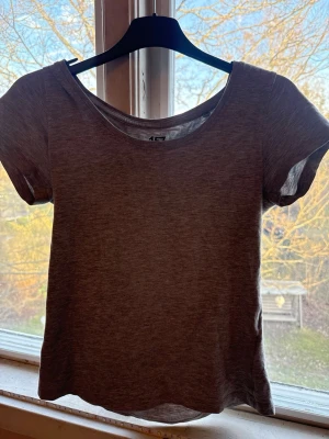 Grå t-shirt från 157, storlek S - En enkel och stilren grå t-shirt från 157 med rund hals och korta ärmar. Materialet består av 85% bomull, 10% viskos och 5% elastan vilket gör den mjuk och bekväm. Perfekt för dig som gillar basic plagg med skön passform.