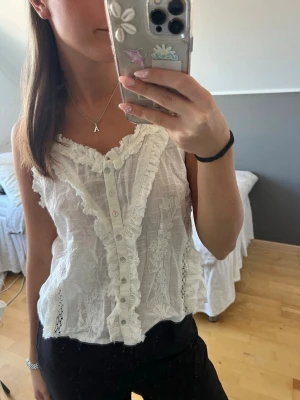 Vit linnetopp - Säljer denna gulliga topp från Zara. Söt vit linnetopp med spetsdetaljer och volang längs v-ringad hals. Toppen är aldrig använd och med prislappen kvar. Säljer den då jag fler liknande toppar🙌🏻😌 