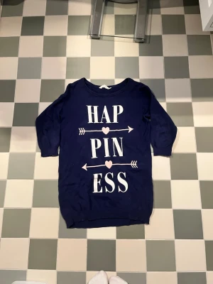 Mjukisklänning  - Mjukisklänning med text Happiness på. 