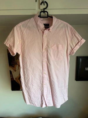 Ljusrosa kortärmad skjorta  - Snygg ljusrosa skjorta från Jack & Jones med korta ärmar och klassisk krage. Missfärgningar i armhålorna men går troligen att få bort
