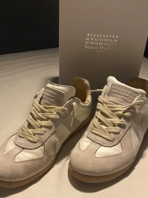 Gats  - MM gats i vitt skinn och beige mocka med klassisk gummisula. Snygg minimalistisk design med snörning och diskreta detaljer. Perfekta för dig som gillar stilrena och trendiga sneakers. Använda typ 8 gånger så dem är fortfarande i bra skick men med små små skavanker👍 skriv gärna vid funderingar eller prisförslag🙂
