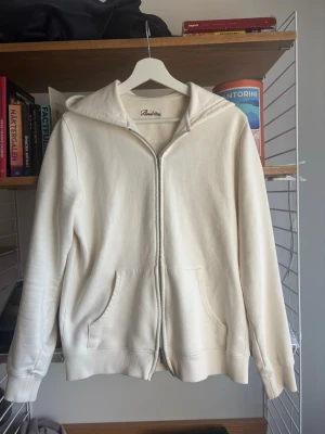 Stenströms zip hoodie - Snygg vit zip hoodie med dragkedja från Stenströms. Klassisk modell med huva, ribbade muddar och två stora fickor framtill. Perfekt för en clean och avslappnad stil. 