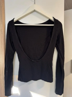 Rygglös svart långärmad topp - Rygglös svart snygg topp, passar till allt och är otroligt fin på 