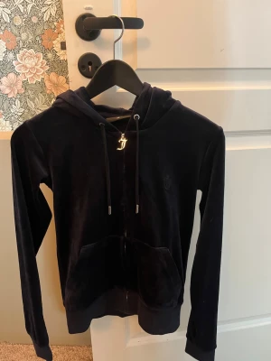 Jätte söt mörk blå juicy coture zip hoodie!💕 - Mjuk och lyxig mörk blå velourhoodie från Juicy Couture med dragkedja, huva och fickor framtill. Snygga detaljer som silverfärgade snörstoppar och ett J-hänge vid dragkedjan. Perfekt för en chill och trendig look.den är äkta! Pris kan diskuteras!💕💕storlek XS