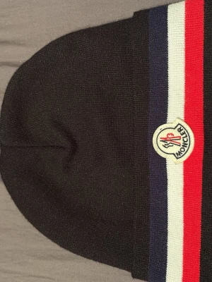 Svart Moncler mössa med ränder - Moncler mössa oanvänd 