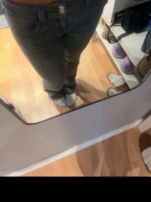 Mörkgrå slim fit jeans - Säljer ett par mörkgrå slim fit jeans med klassisk femficksdesign och låg midja. Jeansen har dragkedjegylf och knapp framtill. Perfekta för dig som gillar en enkel och stilren look.
