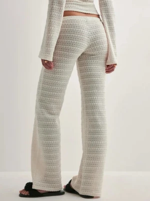 Vita virkade leggings med utsvängda ben - Säljer ett par vita virkade leggings med utsvängda ben och hög midja. De har en mjuk och stretchig känsla, perfekt för en avslappnad och trendig look. Materialet är stickat och ger en unik struktur. Passar dig som gillar boho-stil.