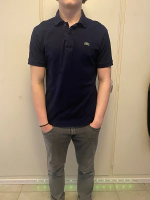 Lacoste piké - Snygg mörkblå Lacoste piké. Sitter bra och skönt, inga defekter!
