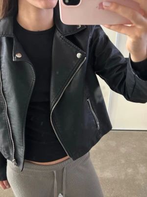 Svart skinnjacka med silvriga detaljer - Snygg svart skinnjacka. Liten i storlek, passar dig som har storlek S/M