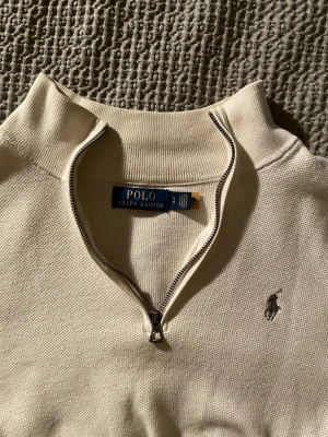 Beige Ralph Lauren half-zip  - Beige half-zip från Ralph Lauren i storlek S. Köpt på Hede Fashion Outlet för något år sedan och är ganska flitigt använd men har fortfarande mycket kvar att ge!