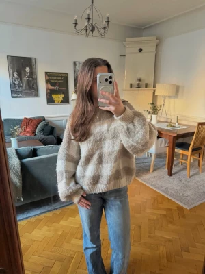Beige och vita randig stickad tröja - Mysig stickad tröja med breda beige och vita ränder! Nopprig men väldigt gosig!