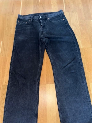 Svarta raka jeans från Weekday - Snygga svarta jeans från Weekday i modellen Space Relaxed Straight. Jeansen har en rak passform och klassisk femficksdesign. Perfekta för dig som gillar en avslappnad stil med lite bredare ben. Materialet är bomull.