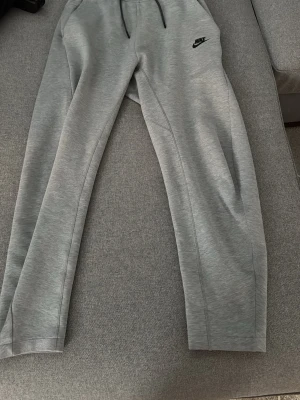 Gråa mjukisbyxor från Nike - Snygga grå mjukisbyxor från Nike med svart logga på vänster lår. Pris kan diskuteras 