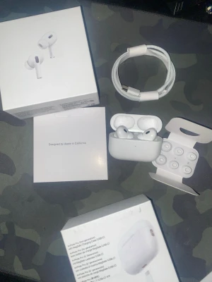Apple AirPods Pro 2 USB-C hörlurar - Säljer ett par vita Apple AirPods Pro 2 med USB-C laddningsetui. Inkluderar originalkartong, laddningskabel och extra silikonpluggar i olika storlekar. Grym brusreducering och smidig anslutning till alla Apple-enheter. Perfekt för musik, poddar och samtal.