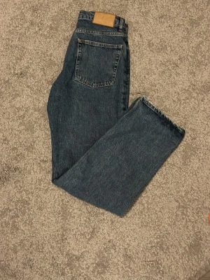 zara jeans - Snygga mörkblå jeans med rak passform och hög midja. Klassisk femficksmodell med läderpatch bak i midjan. Jeansen har en tidlös tvätt och är tillverkade i kraftig denim. Perfekta för en avslappnad och trendig stil.