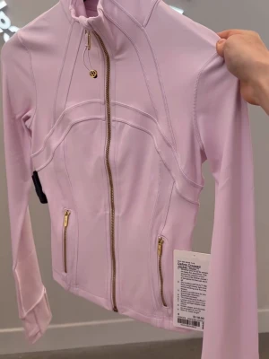 Lululemon define jacket  - Ljusrosa med guldetaljer. Storlek XS. Size 4. Lite skadad över magen. Kontakta för fler bilder. 