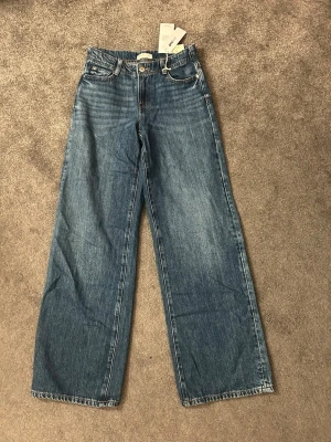 Blåa Baggy jeans  - Säljer ett par helt nya baggy/vida jeans från Gina tricot i storlek 32. Nypris 499. 