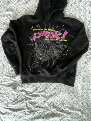 Äkta Spider hoodie - Äkta Spider hoodie i svart med snyggt spindelnätsmotiv. Bekväm passform och i fint skick. Perfekt om du gillar streetwear. 🕷️✨