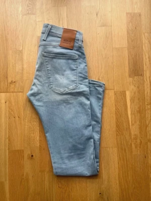 Ljusblå slim fit jeans från Replay - Snygga ljusblå jeans från Replay i slim fit-modell. Klassisk femficksdesign, skinnpatch med logga bak i midjan och diskreta slitningar framtill. Perfekta för en avslappnad och trendig look. Tillverkade i mjukt denimtyg för extra komfort.