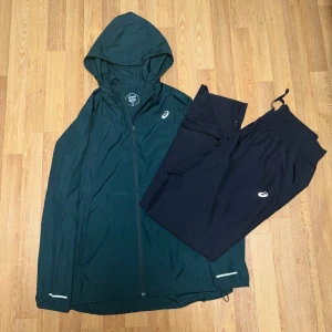 Asics träningsdress Green and Black – Windbreaker M / Pants M - Asics träningsdress i mycket bra skick. Inga skador eller slitage.  Bekväm och funktionell träningsdress som passar perfekt till både träning och vardag.   Size: Vindjacka M / Vindbyxa M                                   🏷️ Rabatt vid köp av flera plagg!