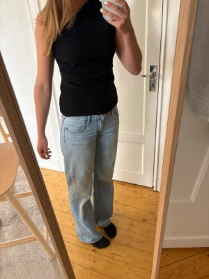 Svart oneshoulder ribbad topp Zara - Snygg svart oneshoulder topp med ribbad struktur. Den är från Zara och är i storlek M