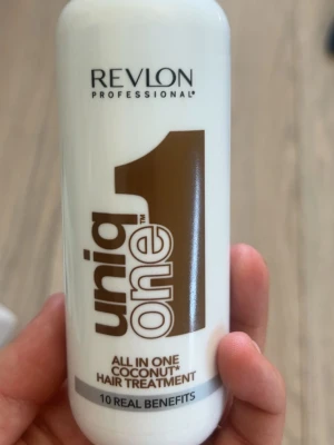 Revlon Uniq One Coconut hårbehandling - Revlon Professional Uniq One All In One Coconut Hair Treatment är en vit plastflaska med brunt tryck. Produkten är en multifunktionell hårbehandling med kokosdoft som ger 10 olika fördelar för håret. Perfekt för dig som vill ha ett smidigt och effektivt hårvårdsspray.