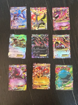 Pokémon EX och Mega samlarkort - Samling med nio Pokémon EX och Mega-kort i färgstarka designer. Korten har holografiska effekter och visar populära Pokémon som Kyogre, Yveltal, Gengar, Groudon och Venusaur. Perfekt för dig som gillar att samla eller spela Pokémon TCG. Vet inte om de är äkta.