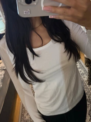 Vit långärmad basic topp - En enkel och stilren vit långärmad topp med rund halsringning. Perfekt att matcha med jeans eller kjol för en clean look. Tunn och mjuk bomullskänsla som sitter skönt på kroppen.
