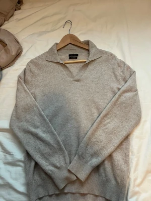 Beige stickad tröja från Massimo Dutti - Snygg beige stickad tröja från Massimo Dutti med krage och v-ringning. 