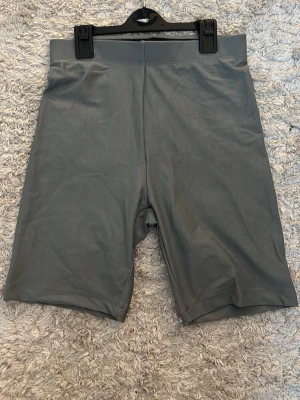 Gröna cykelshorts från BikBok - Gröna cykelshorts från BikBok i stretchigt syntetmaterial. Har elastiskt band inuti för midjan. De har hög midja och en enkel, stilren design utan synliga detaljer. Perfekta för en sportig och trendig look. Gåva vid köp!🎁