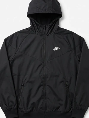 Svart vindjacka från Nike med huva - Snygg svart vindjacka från Nike med dragkedja framtill, två fickor med dragkedja och justerbar huva. Jackan har en stilren design med Nike-logga på bröstet och elastiska muddar vid ärmslut och nederkant. Perfekt för en sportig och avslappnad look.