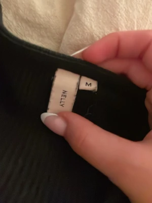 Svart långärmad topp från Nelly - Svart långärmad topp från Nelly med v-ringad halsringning. Toppen har en taight passform, med ribbat material. Skulle säga att den är mer än S än M, knappt använd så väldigt bra skick. Pris kan diskuteras. (Inte så bra bilder då min backkamera är sönder!) Skriv vid frågor. Pris kan diskuteras
