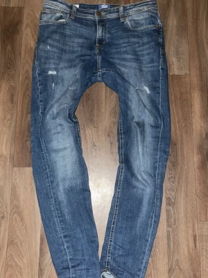 Mörkblåa Jeans med Slitningar - Ett par goa mörkblåa  med slitningar. Storleken på dessa är 31/30. Ganska använda men inget tecken på skada eller någon fläck eller så. Ser helt nya ut enligt mig.